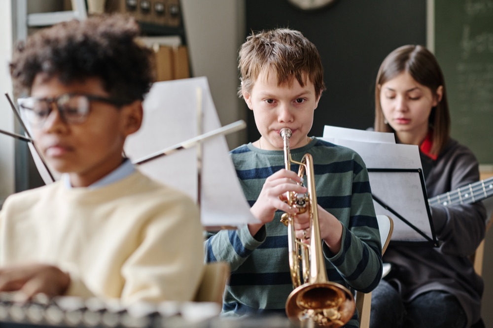 A young trumpet player rehearsing with a school band